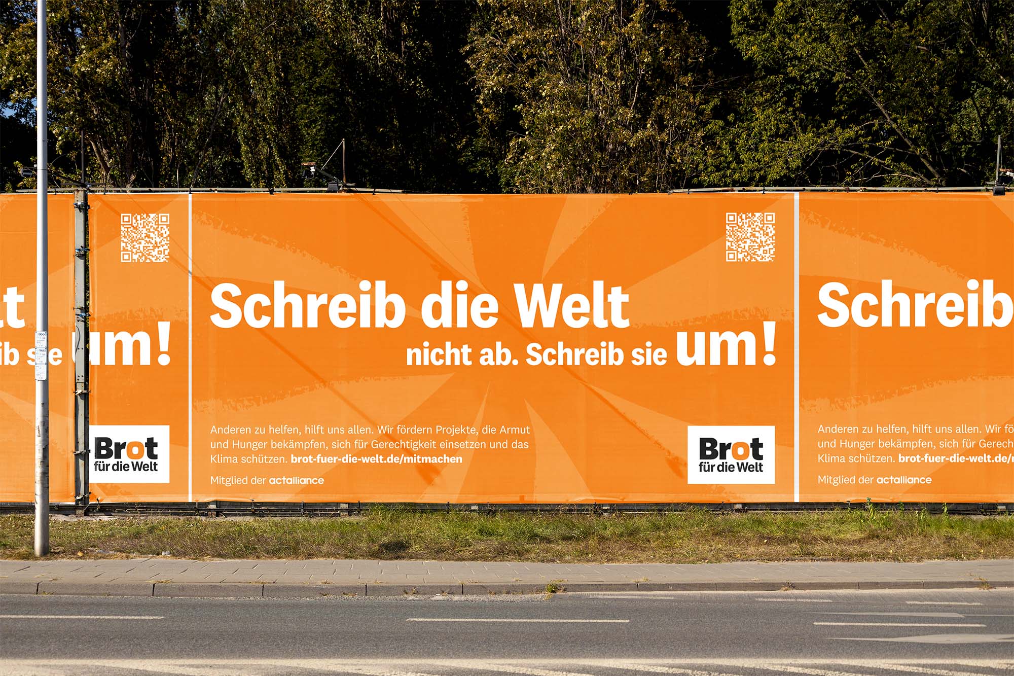 Bauzaunbanner „Schreib die Welt nicht ab. Schreib sie um!“